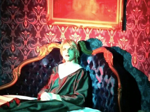 A solitary figure bathed in red, Drab Majesty becomes a striking symbol of transformation, devotion, and the haunting allure of the unknown