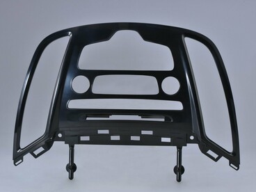 A plastic car dashboard frame that mounts over/around components like air vents, the instrument cluster, or center controls