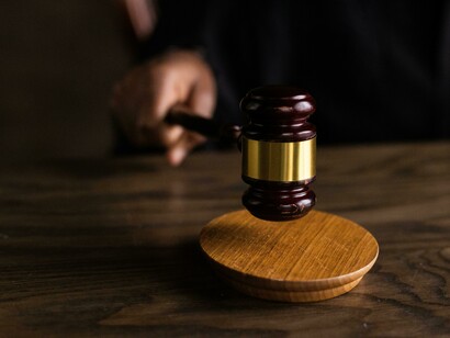 A hand firmly holds a gavel—an emblem of justice and legal authority
