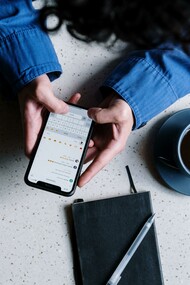 A person sat at a table using social media on a mobile phone