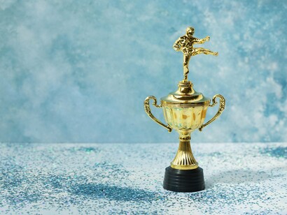 A small trophy placed amidst glitter, reflecting how consistent effort leads to meaningful outcomes