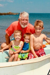 Farfar posing with his grandchildren on his old rowboat
