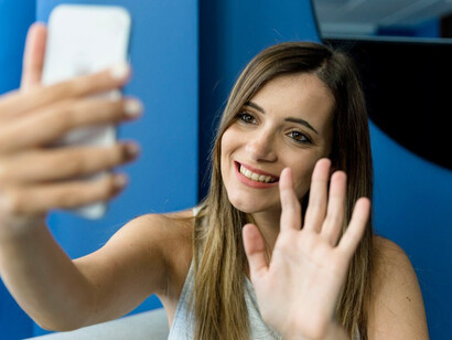 An adult woman using multiple devices, reflecting the challenge of balancing screen time