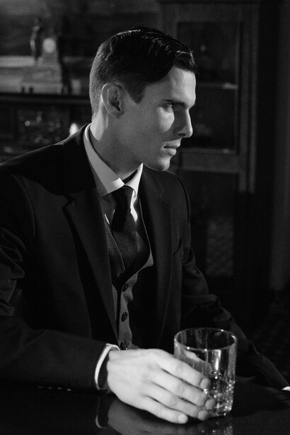 Monochrome photograph of men seated at a bar counter