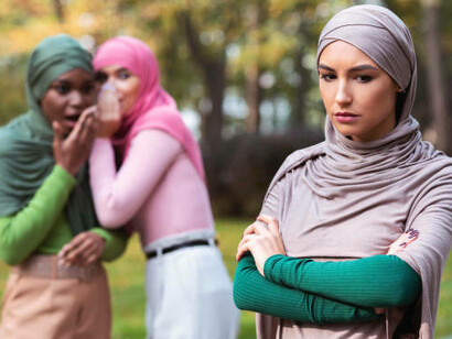 A lonely woman looks distressed while toxic friends talk nearby