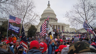 The storming of the USA Capitol on January 6, 2021. Rioters holding USA and “Make America Great Again” flags