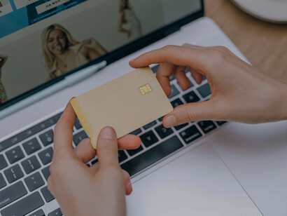 A woman completing an online purchase on her laptop, symbolizing how consumerism can become a coping mechanism for feelings of isolation and disconnection