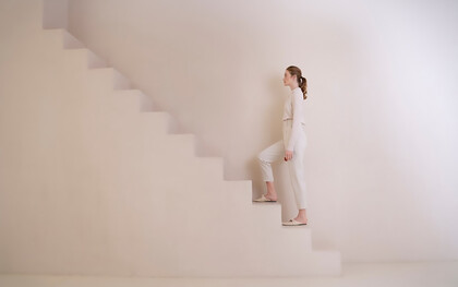 A woman climbing endless stairs, symbolizing the ongoing journey of personal growth and development