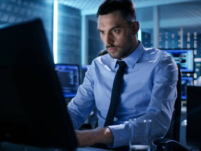 A male engineer analyzes data on multiple screens, representing the fusion of generative AI, real-time monitoring