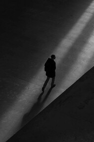 Person walking alone on concrete 