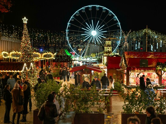 Christmas market beneath an illuminated Ferris wheel in Poznań, Greater Poland Voivodeship, Poland