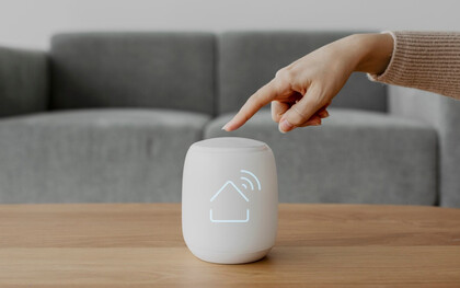 A fingertip activates a smart home hub — symbolizing the connectivity and control of IoT innovation 