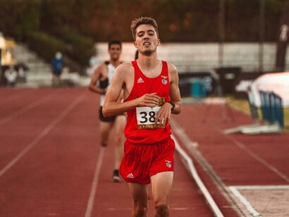 A runner in a red tank top competes in an Olympic race