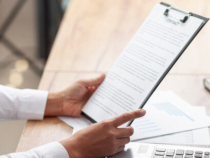 A business professional reviewing papers and contracts during the recruitment and hiring process, reflecting the dynamic between the employer and job candidates