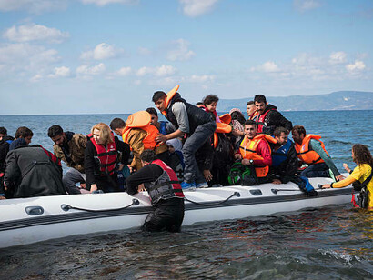 Migrants arrive in small boats on Lesbos, Greece, highlighting the ongoing migration crisis, border enforcement dynamics, and the struggle of refugees crossing international borders
