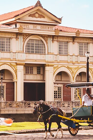 Vibrant yellow and green Kalesa captured against the backdrop of Las Casas in Bagac, Philippines, showcasing the traditional charm and cultural heritage of this iconic mode of transportation