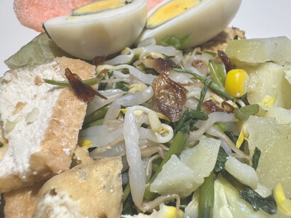 In this close-up, the combination of colourful vegetables, egg, and tempeh offers a glimpse into the cultural significance and deliciousness of Jakarta’s gado-gado salad