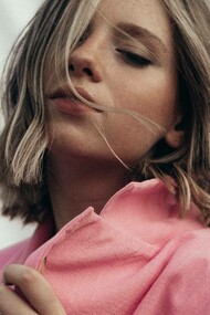 A woman wearing a desert rose color coat