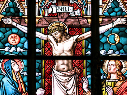 Stained-glass windows glowing with scenes of the crucifixion, presenting how Christianity frames faith, sacrifice, and identity