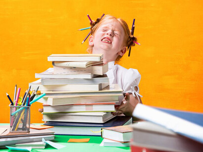 A redhead teen girl sitting amidst a stack of books at home, overwhelmed by academic pressure and mental health challenges
