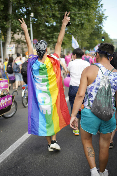 People gathering on the streets of Paris, France, wearing rainbow flags and celebrating LGBTQ+ pride