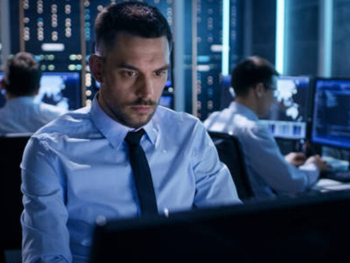 An AI specialist works at a desk surrounded by dynamic displays, symbolizing knowledge mediation