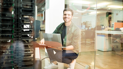 Portrait of a young network engineer holding a laptop while working in a data center