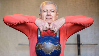 An elderly man lifting a heavy kettlebell, symbolizing longevity, healthspan optimization, and physical resilience