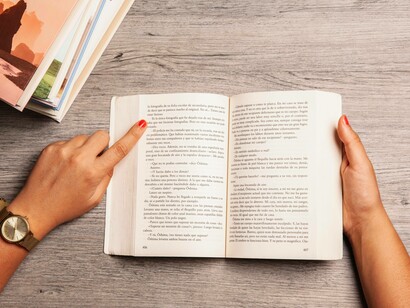 Donna che legge un libro indicando con un dito un punto della pagina: "più il testo è lungo, per proporzione diretta, più cresce la possibilità di errore. Praticamente il nostro cervello “aggiusta” di default, e così il refuso sfugge"