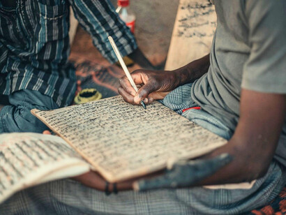 A young boy studying, capturing the innocence repeatedly caught in the crossfire of extremism