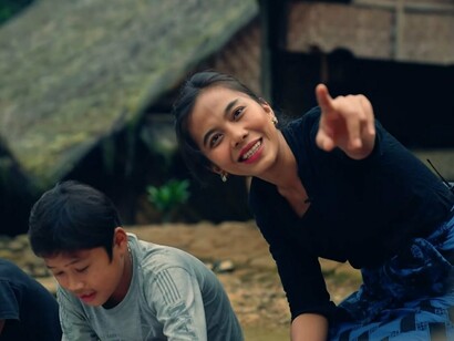 A playful moment between a woman and a child, reflecting the simplicity and warmth that define Baduy villages