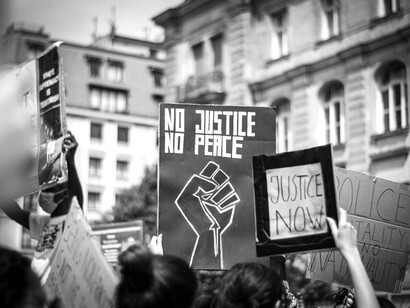 Grayscale image showing people engaged in a demonstration