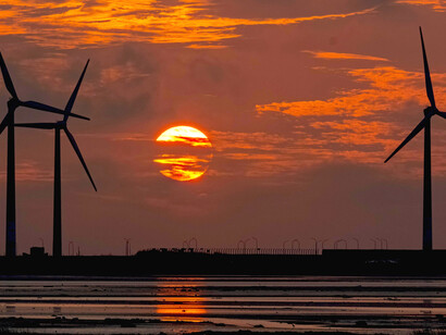 Wind turbines turning at sunset, a striking image of the global shift toward renewable energy