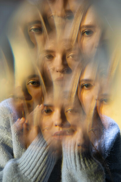A distorted photo of a woman set against a maze evokes the inner entanglement of identity, thought, and direction