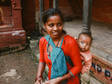 In a traditional environment, a young mother with her child represents the struggles of poverty and the reality of girls denied education