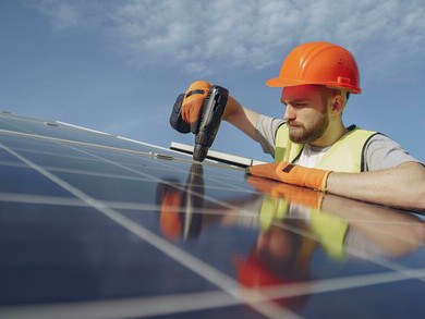 An electrician installing solar panels as part of a renewable energy project