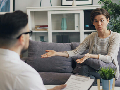 A man and a woman are sitting on a couch, deep in conversation