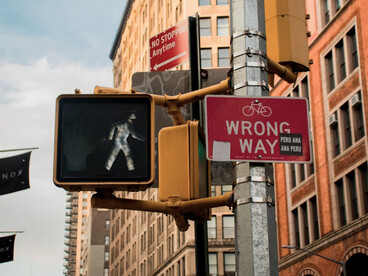 A street sign mounted next to a traffic light on a busy New York City street, USA