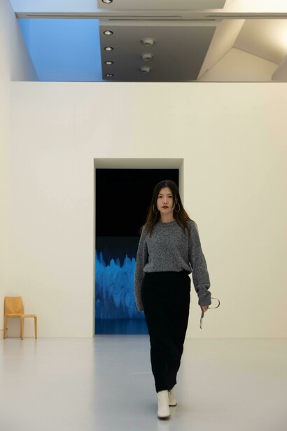 Back view of a woman walking through a modern, white museum space