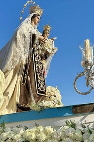 L'image montre une statue religieuse, spécifiquement identifiée comme une statue de la Vierge Carmen lors d'une procession dans la ville d'Andalousie, en Espagne