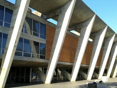 Ao chegar ao Museu de Arte Moderna do Rio de Janeiro (MAM RJ), o visitante é imediatamente envolvido por uma cena que mistura concreto, céu e mar. O prédio, projetado por Affonso Eduardo Reidy, é um marco da arquitetura modernista brasileira. Suas linhas retas e estrutura aberta parecem flutuar sobre o Parque do Flamengo, enquanto os jardins de Burle Marx completam a harmonia entre arte e natureza