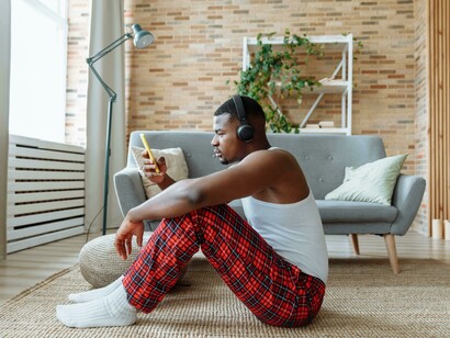 A person sits alone at home, scrolling through his phone—a quiet moment of individualism