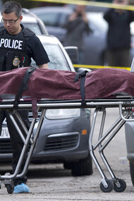 Police remove a body from the scene of a multiple fatal stabbing in northwest Calgary
