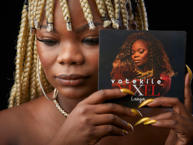 Um álbum surpreendente. Um disco solar, num país cinzento. Uma obra onde são percetíveis a dor de perder um pai, a dor de ser explorada e roubada, a dor da saudade, o amor à tradição, o sacrifício do trabalho para sustentar os (nossos) dependentes, abusando, num universo próprio, de elementos das mais diversas tipologias, como rock, jazz, bossa nova, psicadelismos, ambientalismo, africanismos, vários ou eletrónicas, sobretudo com uma descontração imensa e imersiva. É coisa rara por estes lados: um disco simultaneamente bem executado e capaz de respirar espontaneidade e graça por todos os poros