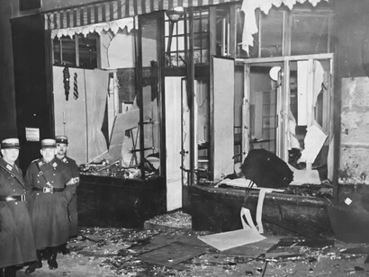 Los ciudadanos alemanes miran hacia otro lado, el 10 de noviembre de 1938, al día siguiente de la Noche de los Cristales Rotos. Lo que ven, o no quieren ver, son las tiendas y casas judías destruidas. Imagen de los pogromos de noviembre de 1938. Una sucursal de la fábrica de paraguas berlinesa Lichtenstein & Co. dirección desconocida, Berlín, Alemania