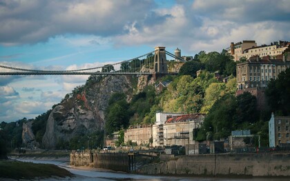 Bristol, England, United Kingdom – a bridge spanning the river against a town and mountain landscape