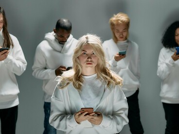 A group of individuals engrossed in their phones, conveying how modern life blurs attention and awareness