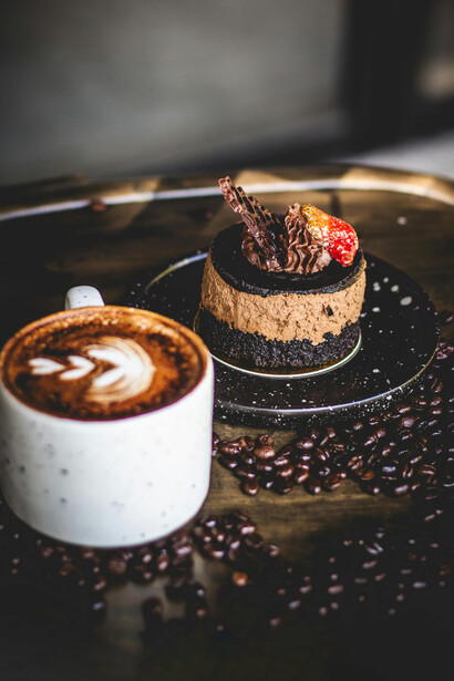 Constanze está sentada en la cafetería Austriaca *Cora*, en plaza Ñuñoa. Mira pensativa el trozo de su torta favorita
