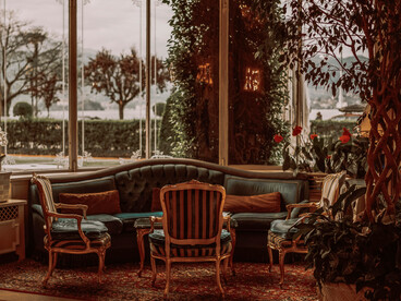 The space features elegant architecture, beautiful views, refined chairs, shimmering chandeliers, classic décor, and luxurious hotel interior design