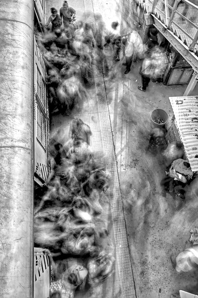 Amid the blur of a fast-moving crowd at a train station, time becomes a force that erases presence and connection—echoing the pressures of modern hyper-speed living